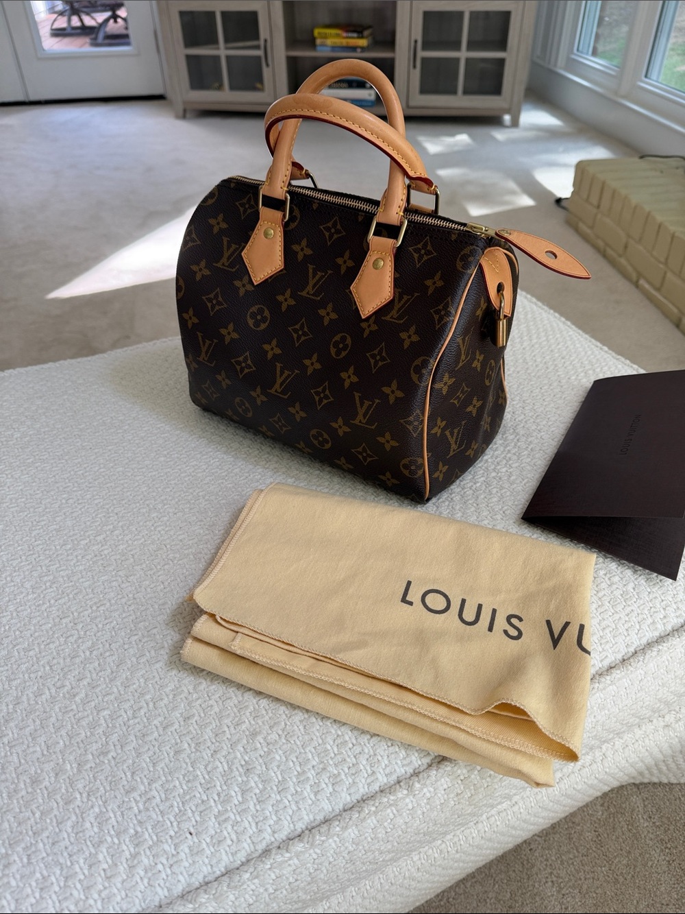 Louis Vuitton Brown Monogram Canvas Speedy 25 with tan handles.